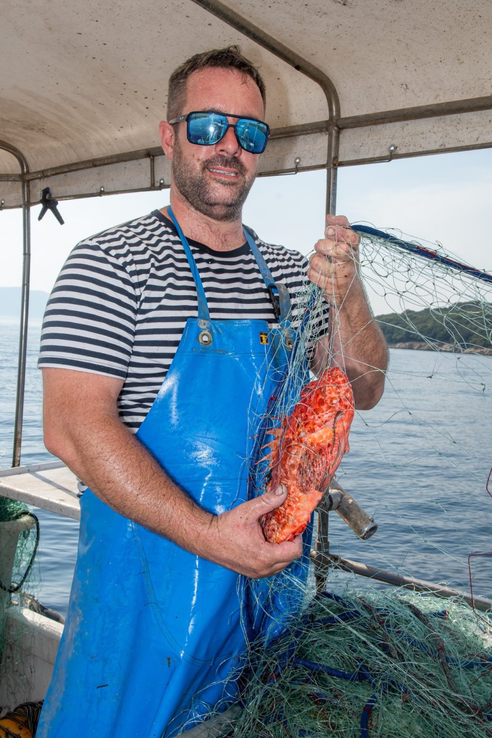 Naš ribar Siki na brodu s mrežom i svježom ribom iz Kvarnera